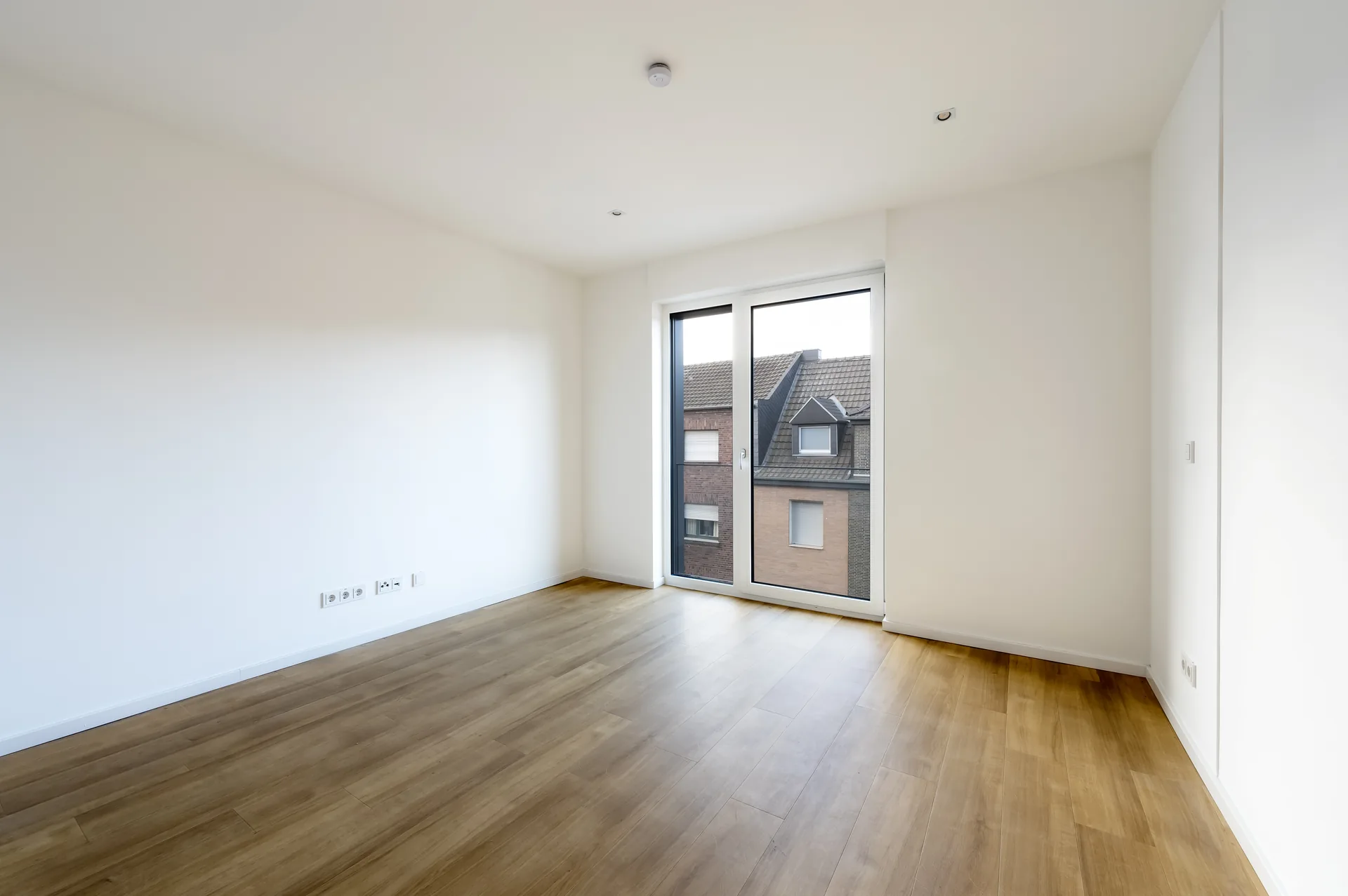Helles Schlafzimmer mit bodentiefen Fenstern und Blick auf die Umgebung im Lifestyle-Apartment, Quartier am Wasserturm