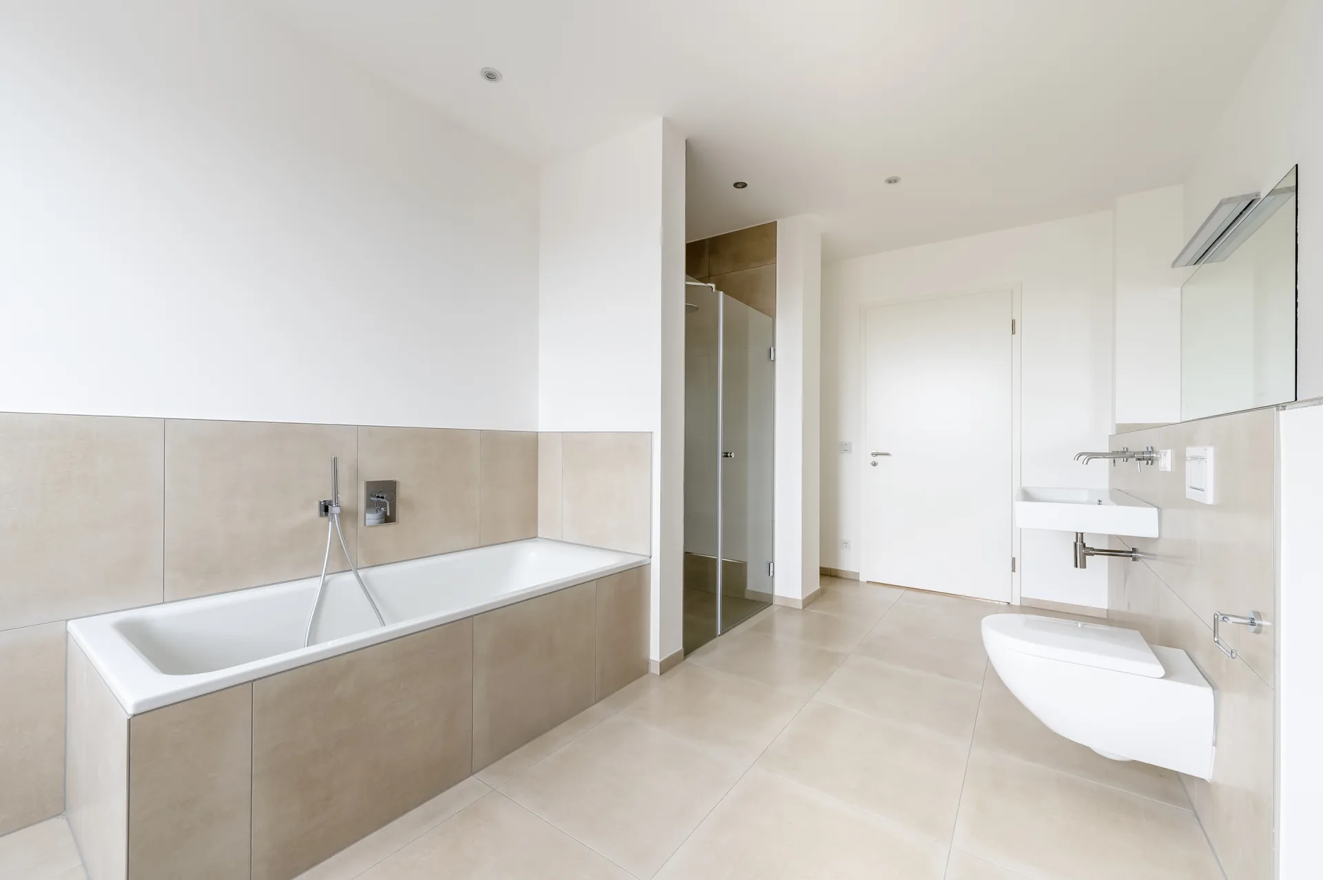 Großes Badezimmer mit Badewanne, Glasdusche und Designer-Armaturen im Luxus-Apartment Mönchengladbach