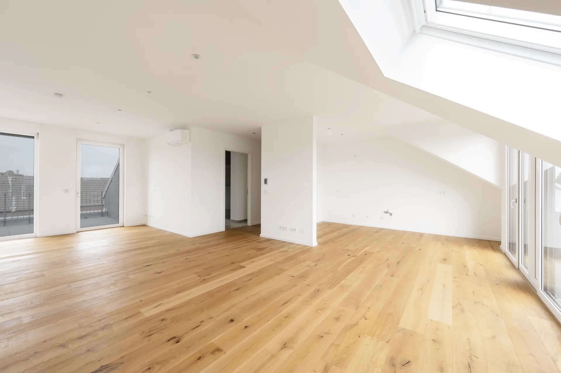 Heller offener Wohnbereich mit Dachfenster und großen Fenstertüren im Luxus-Penthouse, Quartier am Wasserturm