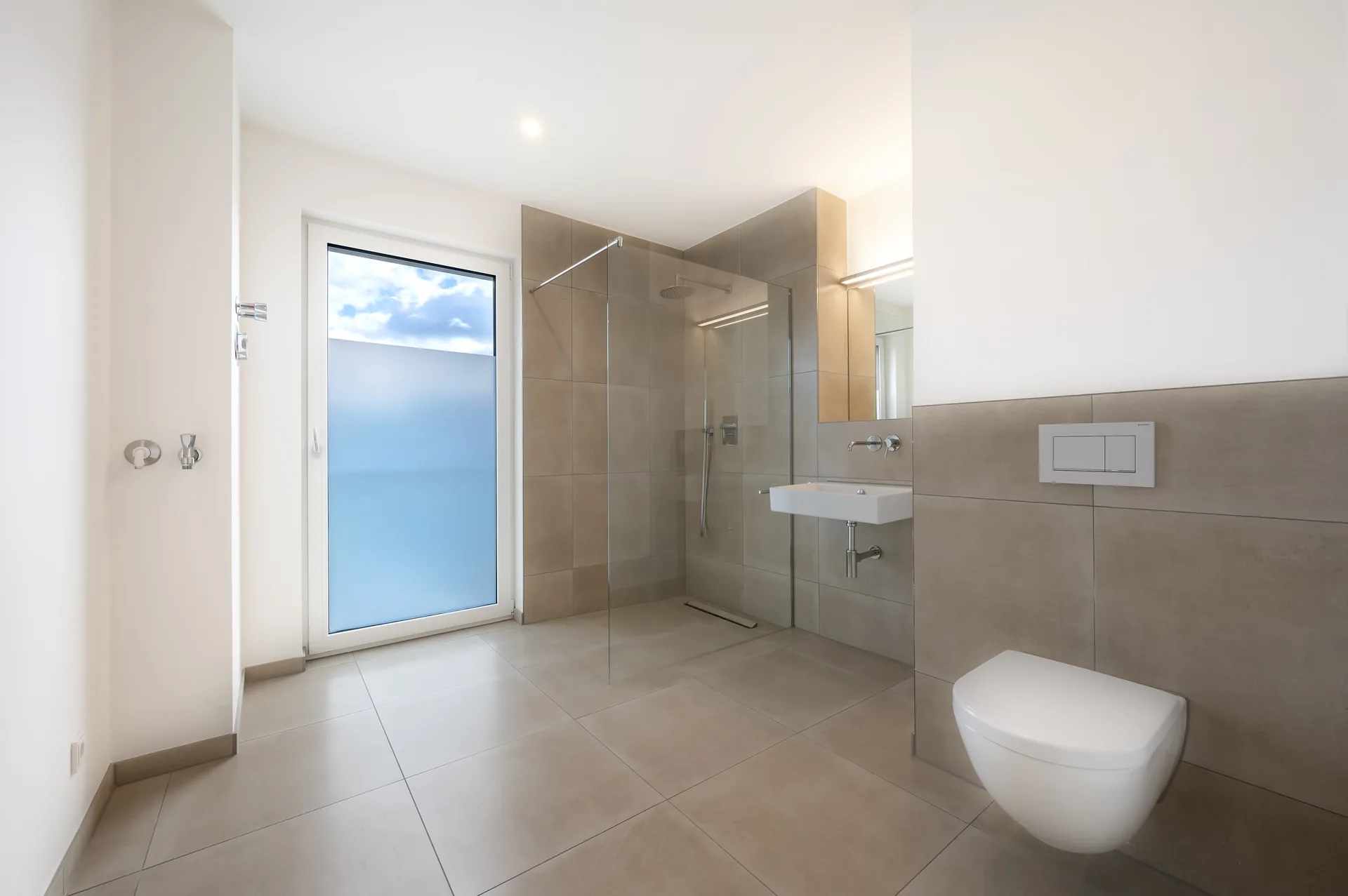 Großzügiges Badezimmer mit bodengleicher Regendusche und Naturstein-Fliesen im Premium-Apartment, Quartier am Wasserturm