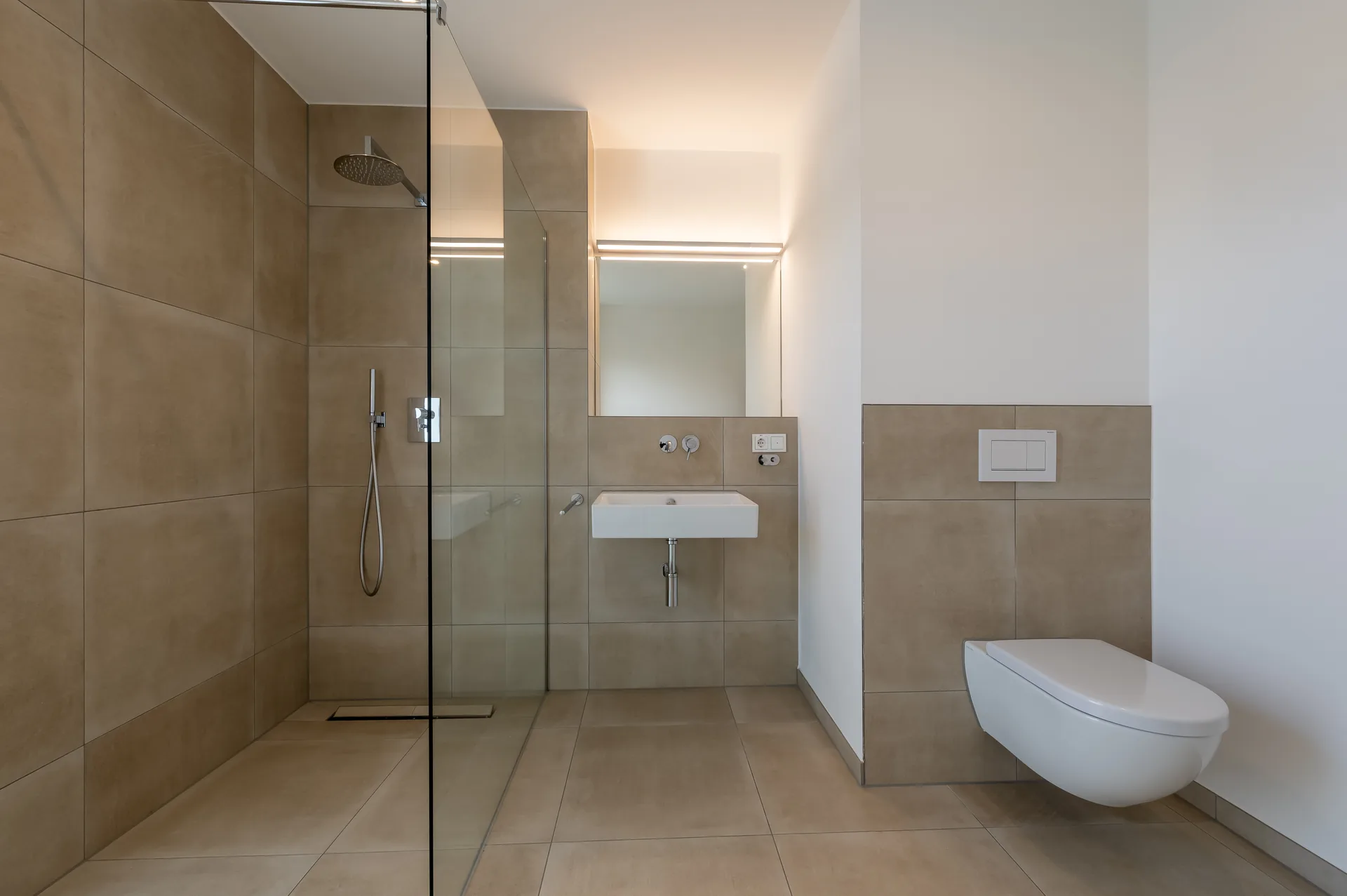 Modernes Duschbad mit ebenerdiger Glasdusche und hochwertigen Armaturen im Premium-Apartment Mönchengladbach