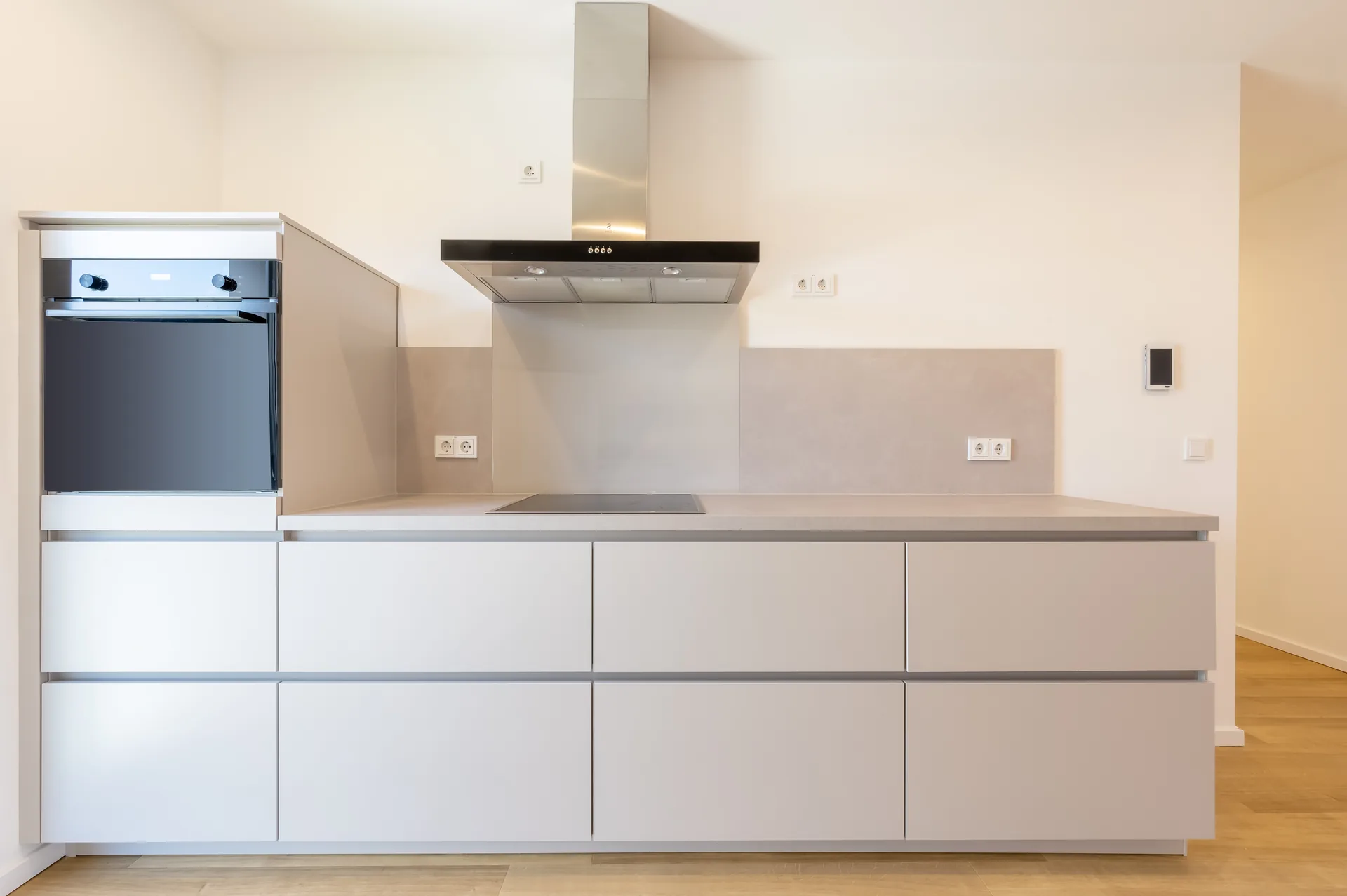 Premium-Einbauküche mit Backofen, Kochfeld und Edelstahl-Dunstabzugshaube im Quartier am Wasserturm