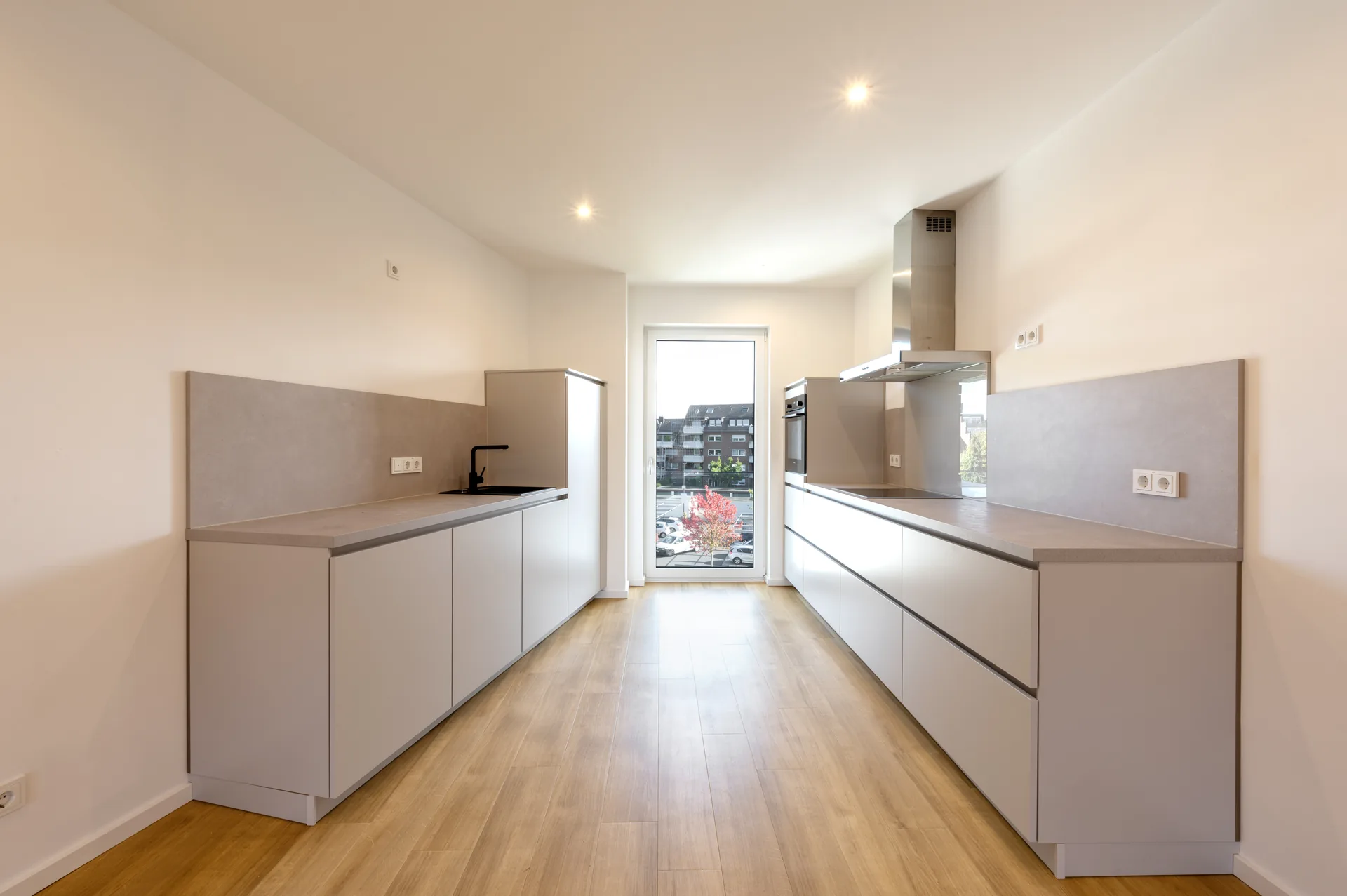 Großzügige Durchgangsküche mit doppelter Arbeitsplatte und Balkonzugang im Premium-Apartment Mönchengladbach